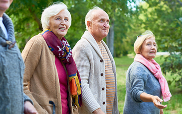 elderly people walking outside together smiling