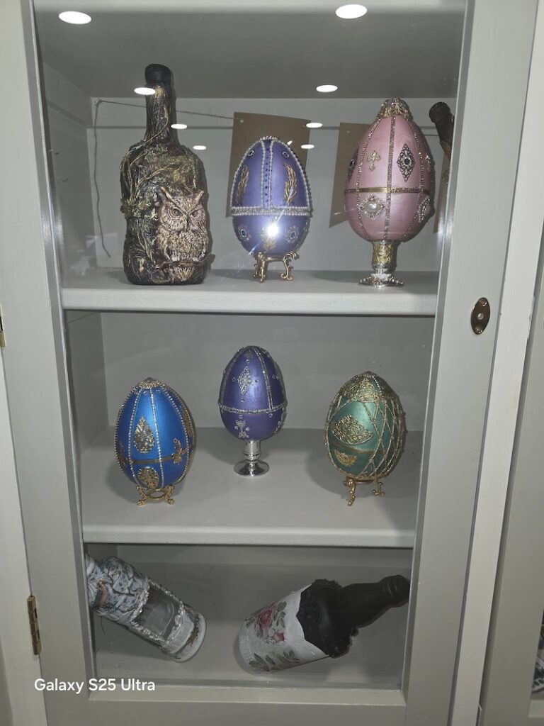 painted art pieces on display in a cabinet