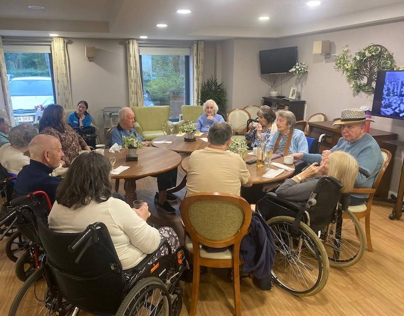 group of residents sat around a table together chatting