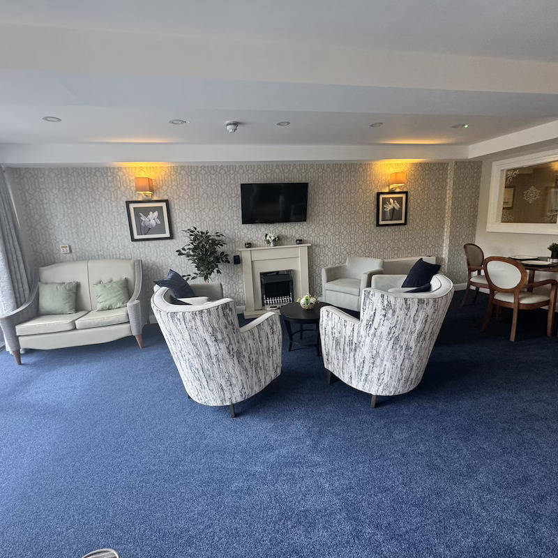 a side view of our residential lounge with armchairs, a sofa and a dining table