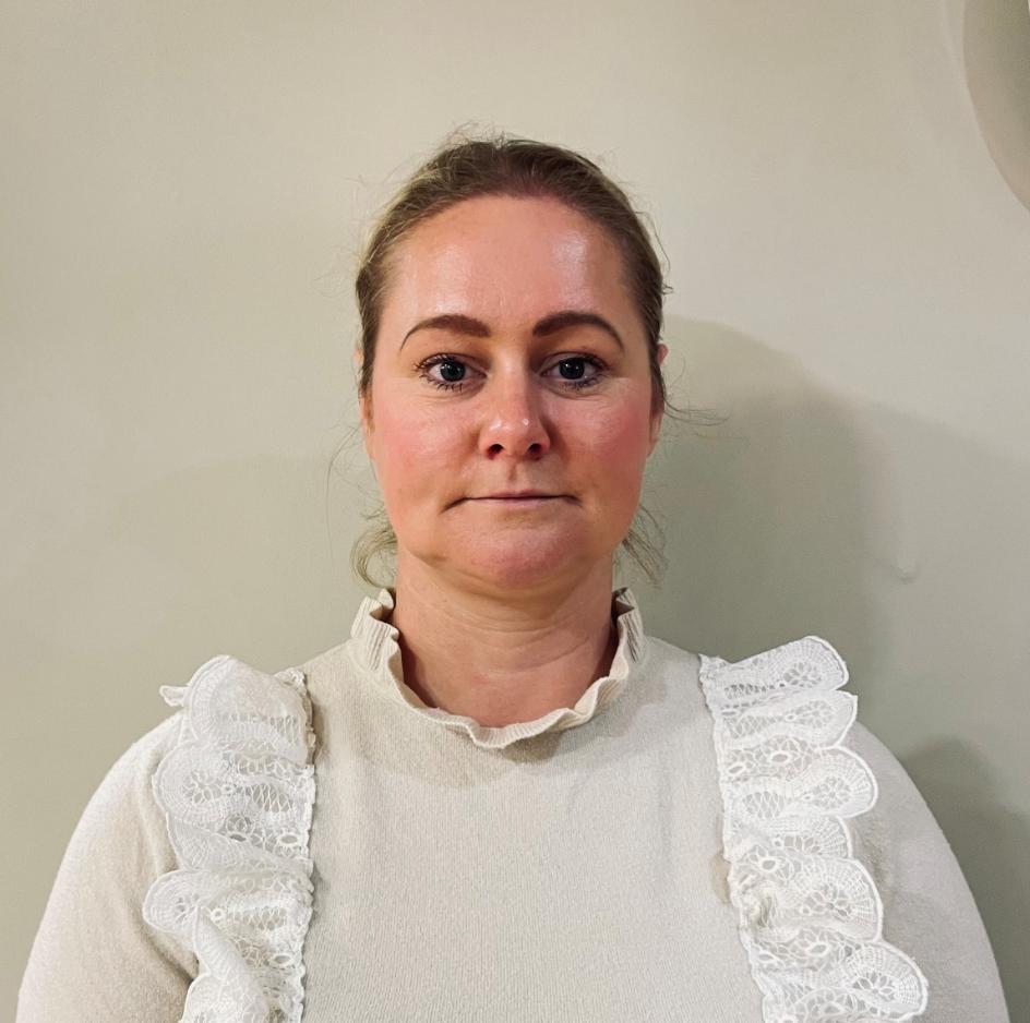 lady in white top posing for staff photo