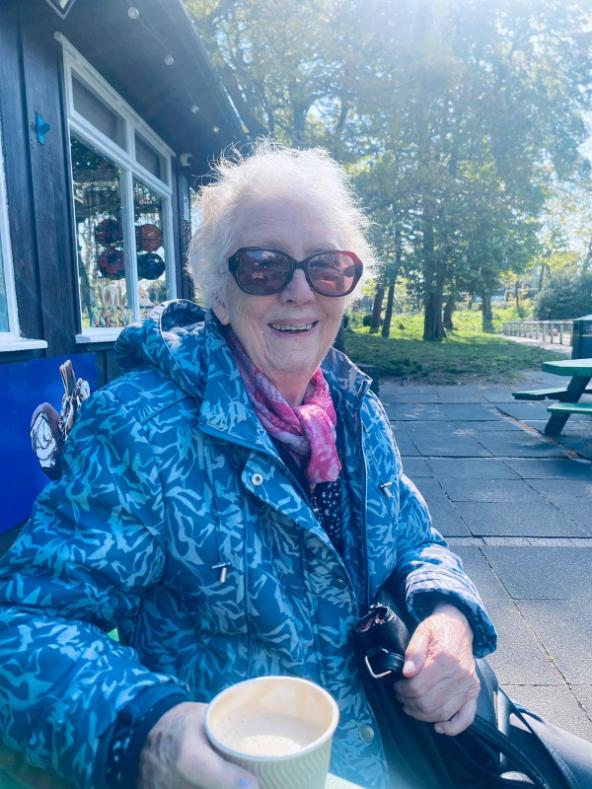 older lady holding a coffee