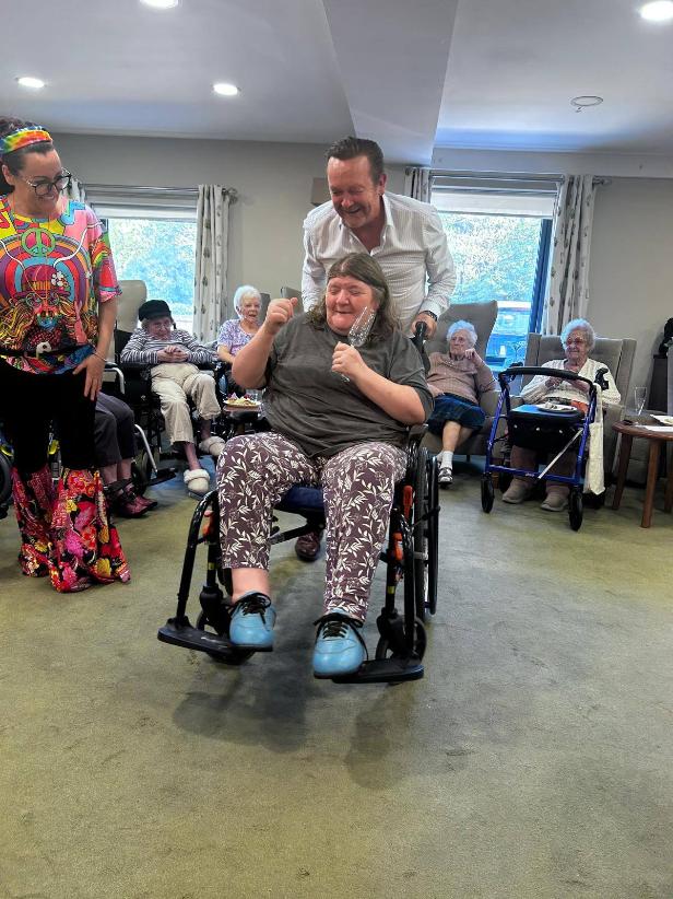 lady in a wheelchair beinng pushed at a party