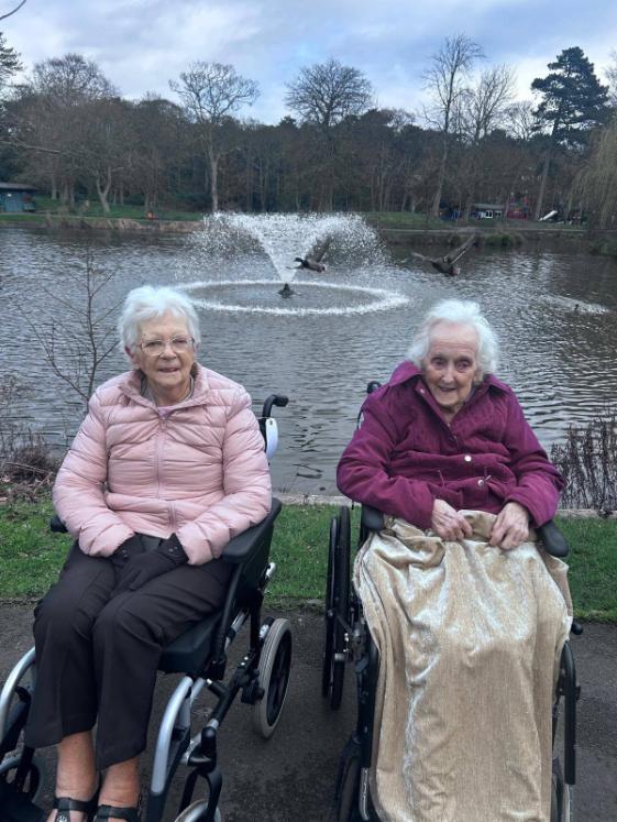 two older ladies sat outside in wheelchairs