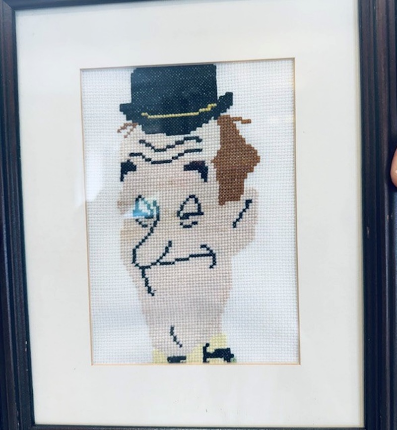 cross stitch of a man wearing a black top hat